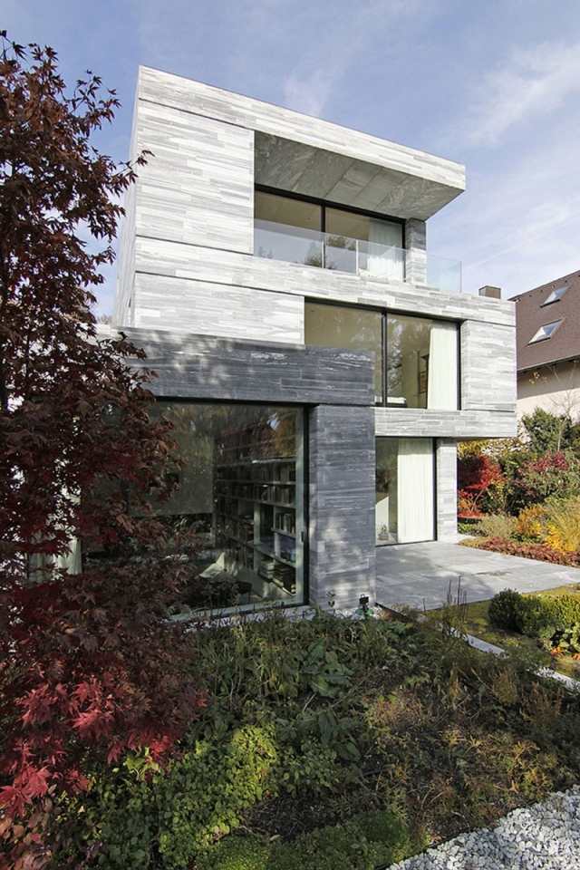 betonhaus-steinverkleidung-Innen-und-Außenbereich-durch-Terrassen-verknüpft