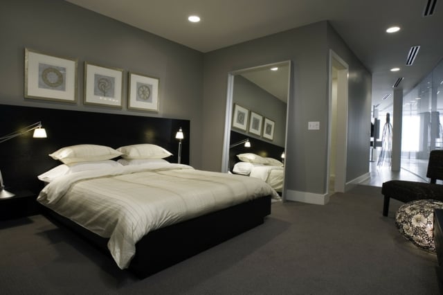 graue Wände schwarzes Bett moderne Gemälde Teppichboden