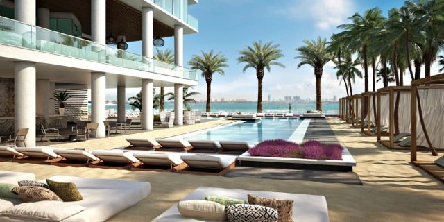 luxus-pool-anlage-mit-sand-sonnenliegen-bequeme-kissen-palmengarten