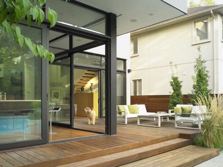 Moderne Terrassen Ideen holzbodenbelag-weisse-moebel-ziergraeser-holz-sichtschutzzaun
