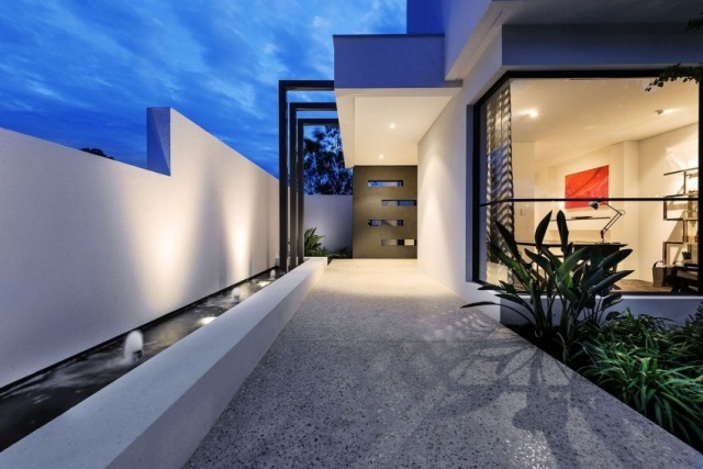 modernes-betonhaus-hohe-sichtschutz-betonmauer-eingang-dekorative-platte