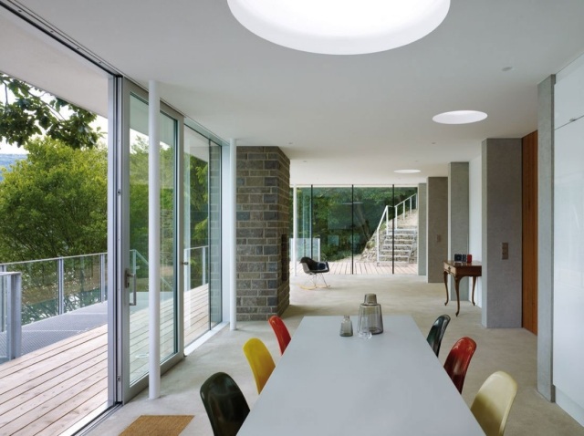 modernes-haus-see-essbereich-glas-schiebetueren-zugang-balkon