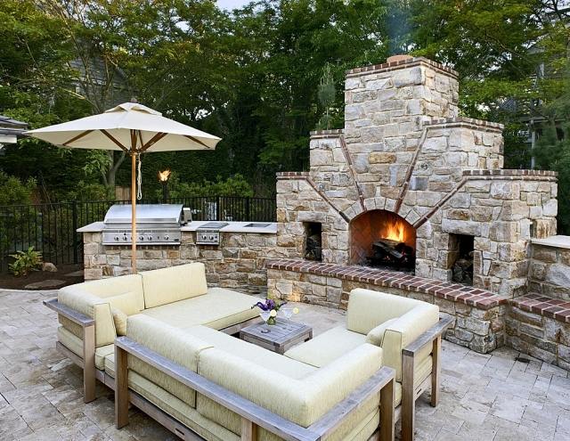 terrassengestaltung-außenbereich-sonnenschutz-outdoor-küche-stein-mauerwerk-kamin-sofa