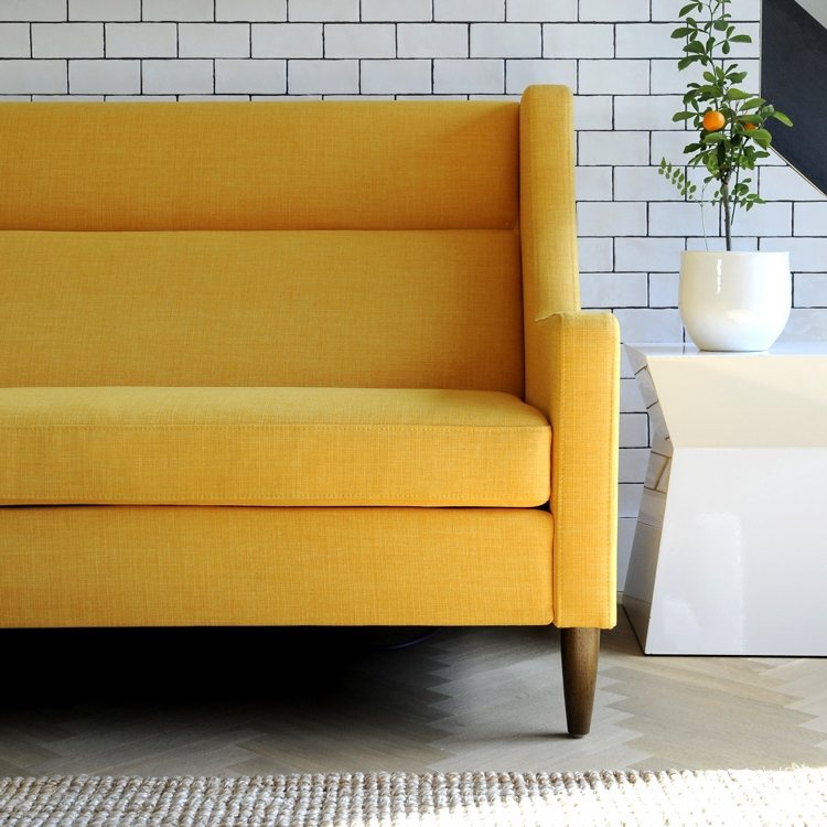 wandgestaltung-wohnzimmer-ziegelwand.weiss-tapete-modern-sofa gelb-polster