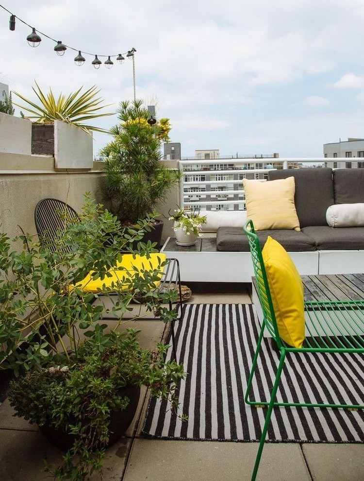 wohnzimmer-freien-betonplatten-outdoor-teppich-gruene-pflanzen-gelbe-akzente