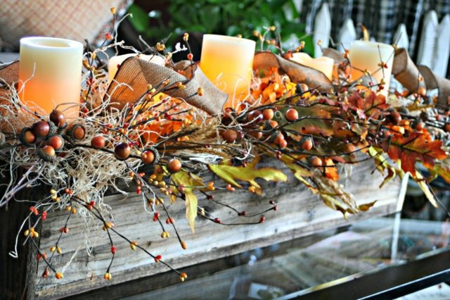 Tisch Deko arrangieren Kerzen Herbstblätter Hagebutte