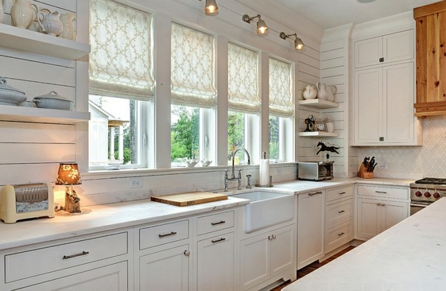 Küchenbereich-mit-Faltrollos-an-den-Fenstern-weiße-Holzküche