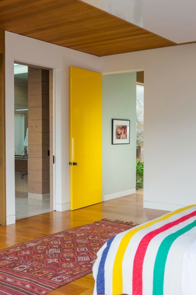 Schlafzimmer einrichten gelbe Tür Kilim originelle Bettdecke Streifen
