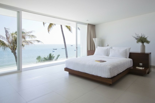 Schlafzimmer-mit-Blick-auf-Ozean-mit-Palmen-Bett-Massivholz