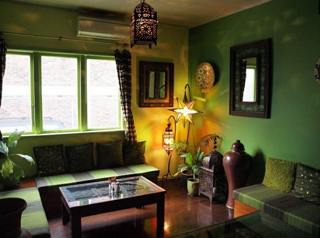 Sitzkisten-mit-Kissen-und-Teppichen-grüne-Fensterrahmen