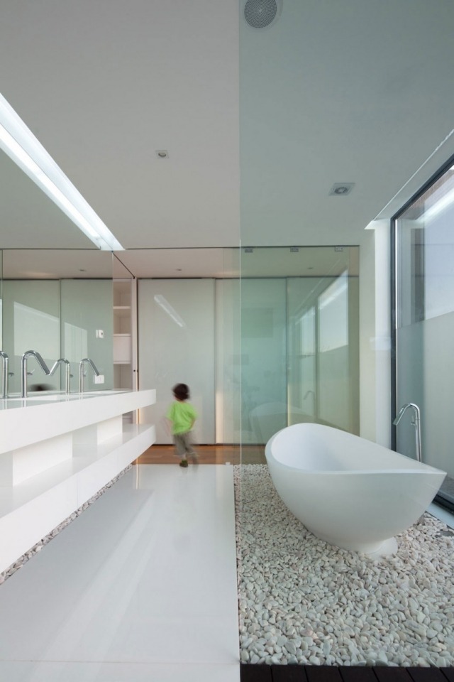 minimalistisches-bad-barrierfrei-weiße-möbel-badewanne-fußboden-flusssteine