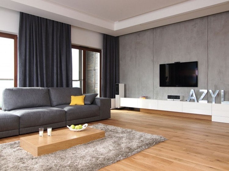 modern-wohnen-wand-betonoptik-holzboden-graues-sofa-vorhaenge