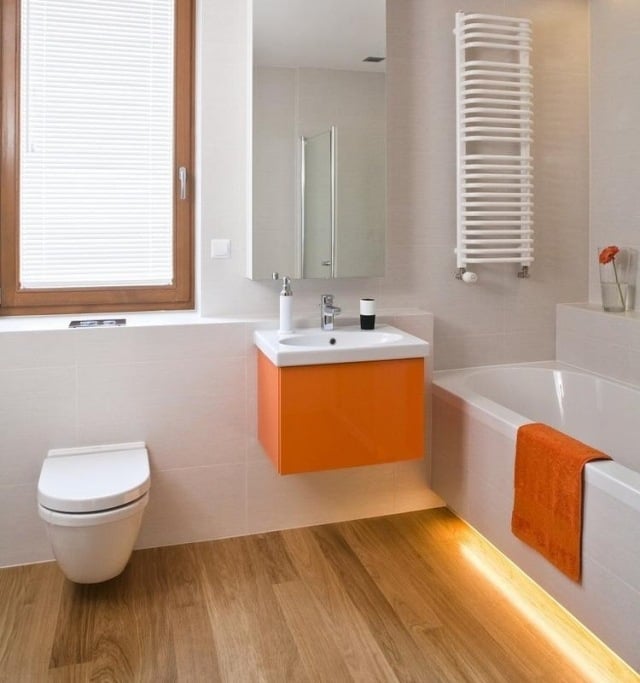 modernes-bad-badewanne-led-leiste-bodenfliesen-holzoptik-orange-waschtischschrank