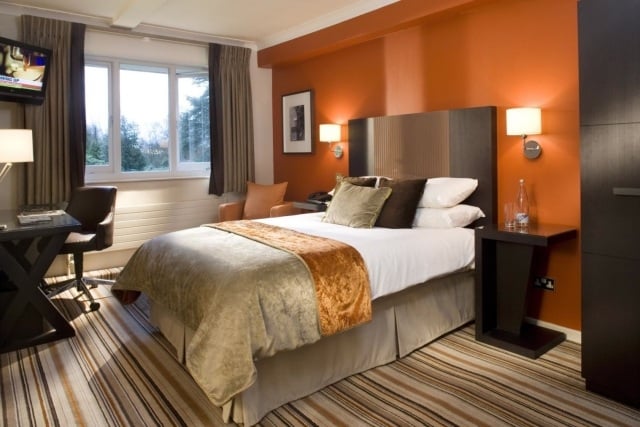 schlafzimmer-wandfarbe-orange-gestreifter-teppichboden