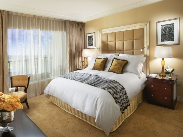 schlafzimmer mit großer Fensterfront grosses-fenster-goldene-wandfarbe-gardinen