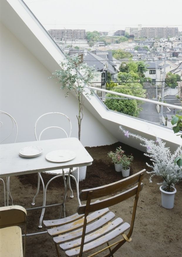 städtischer-balkon-fußboden-mit-erde-naturnahes-ambiente-shabby-stühle