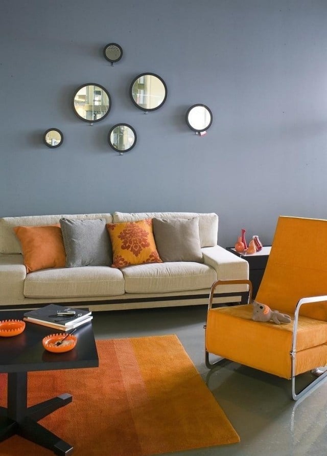 wohnzimmer-wandfarbe-grau-orange-akzente-deko-runde-spiegel