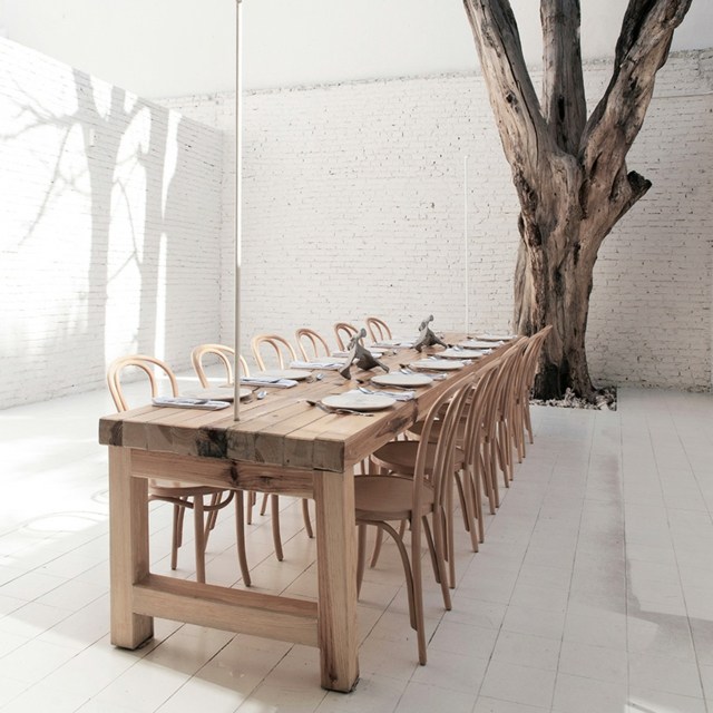 Backsteinwand-toter-Baum-Massivholz-Tisch-mit-Stühlen