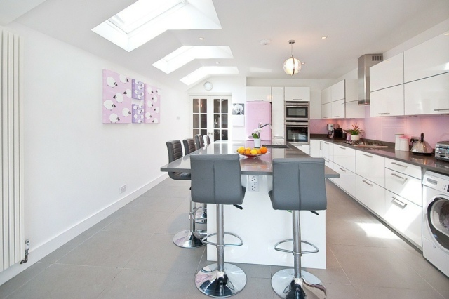 Dachgeschoss-Wohnung-Küche-mit-Fenster-an-der-Zimmerdecke-weiße-Schränke-mit-rosa-Wand