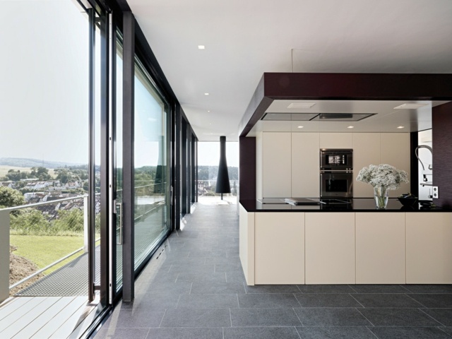 Eierschalenfarbe-und-schwarz-in-der-Küche-mit-Wand-aus-Glas-und-Schiebefenster