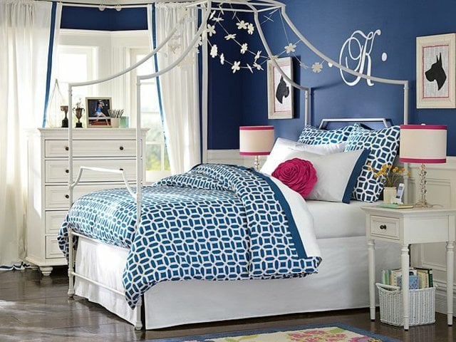 Himmelbett-aufgehängte-Figuren-blaue-Wand-und-Bettwäsche-mit-Muster
