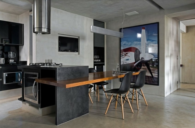 Kücheninsel-aus-Granit-mit-Beton-Wänden-schwarze-Stühle