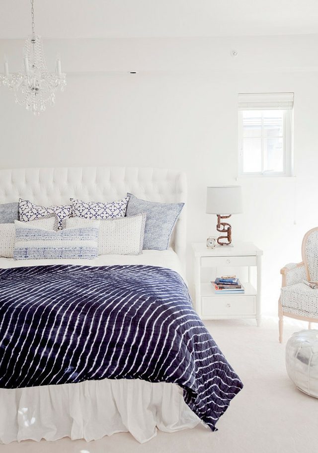 Schlafzimmer-weiße-Wände-Kronleuchter-gestreifte-Bettdecke