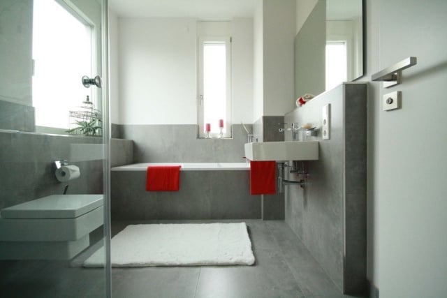 badezimmer-gestaltung-graue-fliesen-matt-rote-handtucher-akzent