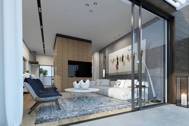 design-wohnzimmer-weisses-sofa-runder-couchtisch-grauer-teppich-sessel-flachfernseher