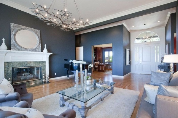 luxuriöse-Ausstattung-im-Wohnzimmer-in-Silberfarben-Polstersofas-Kamin-und-ausgefallenem-Tisch