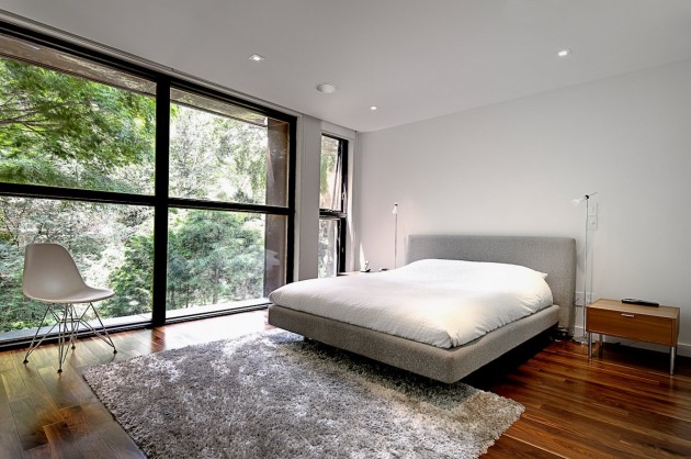 modernes-schlafzimmer-grosser-fensterfront-graues-polsterbett-holzboden