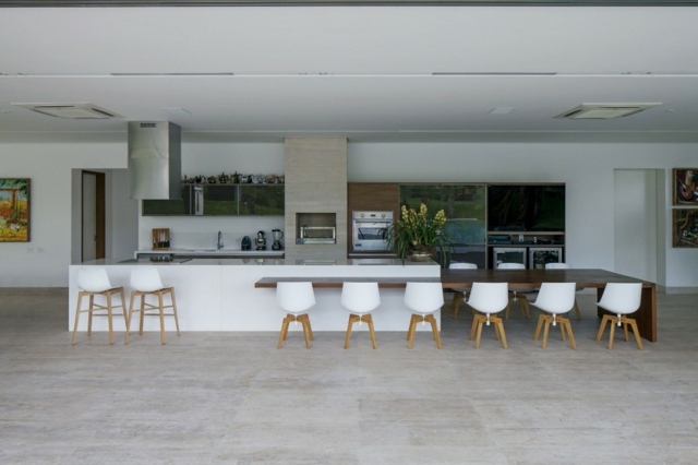 riesige-Küche-mit-langem-Tisch-weiße-Kunststoffstühle-schwarz-weiße-Ausstattung