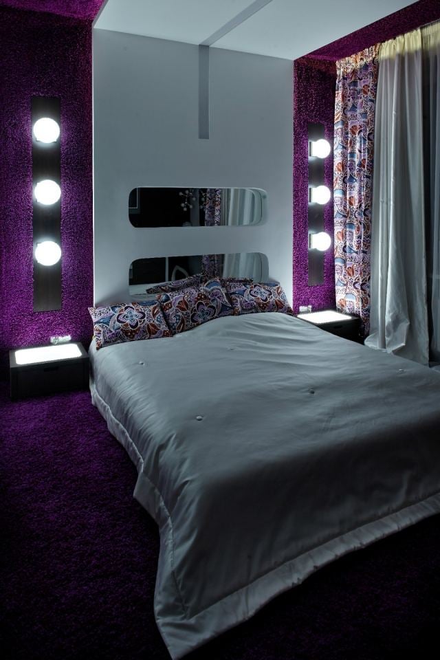 schlafzimmer-wandgestaltung-stoff-gepolstert-aubergine-lila-spiegel-wandleuchten