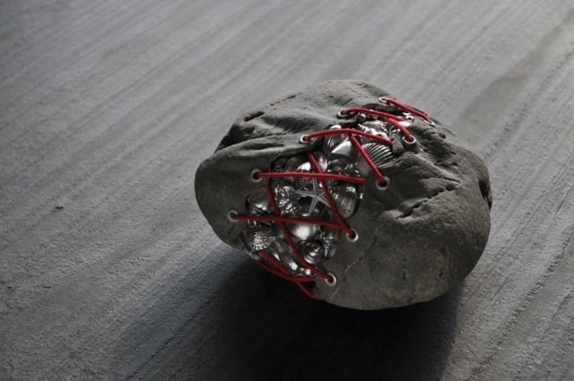 skulpturen aus stein schnüren rote schnur