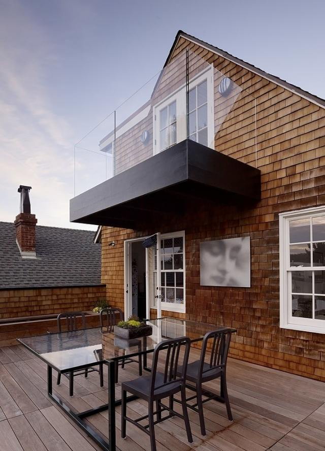 terrasse-modern-gestaltet-dielenboden-glas-esstisch-schwarze-stuehle