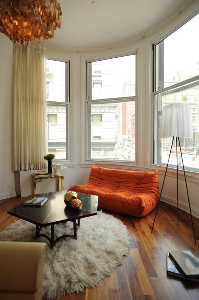 wohnzimmer-modern-einrichten-orange-ligne-roset-sofa-dielenboden-shaggy-teppich