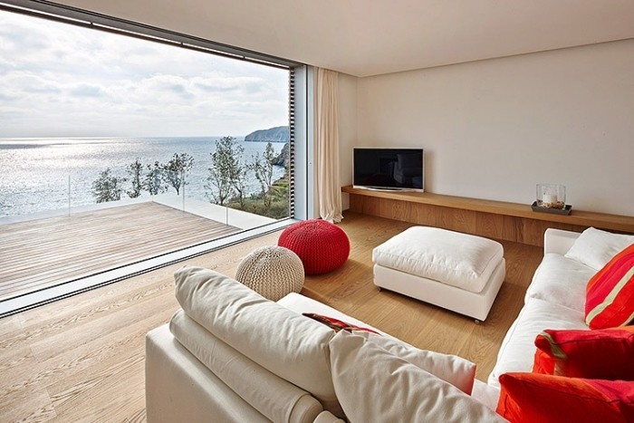 Haus-Innere-Wohnzimmer-Laminat-Holz-puristische-Wohnwand-weiß-rote-couchgarnitur