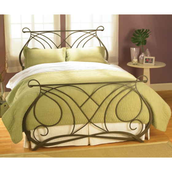 Metall-Bett-mit-grüner-Bettdecke-Holzboden