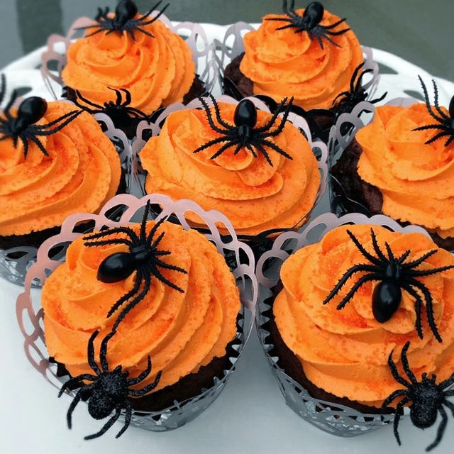Papier-gebastelte-Muffin-Körbchen-Spinnen-auf-orangefarbenem-Schaum