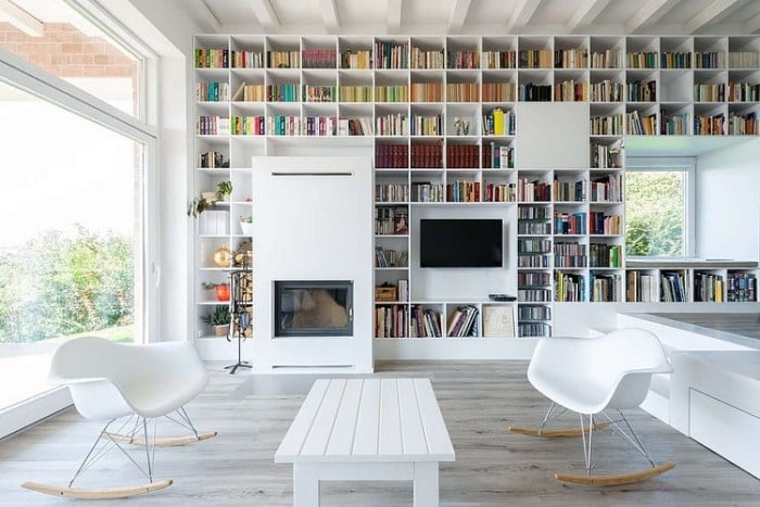 deckenhohe-bücherwand-hausbibliothek-weiß-wohnzimmer-schaukelstühle-design