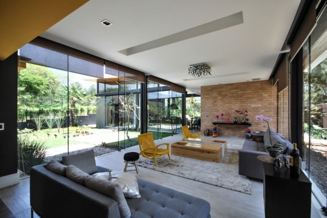 eklektische-wohnzimmer-gestaltung-backsteinwand-stühle-design-gelb