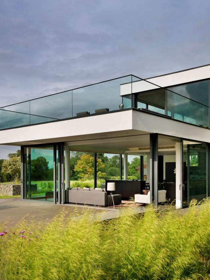 glas-geländer-überdachte-terrasse-modernes-neubauhaus-mit-garten