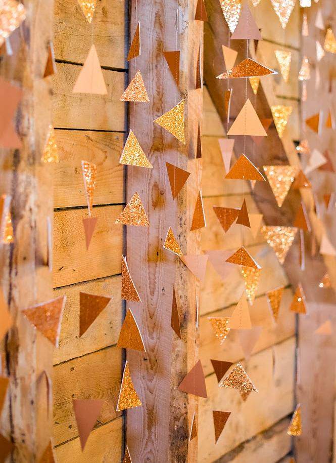hochzeit-rueckwand-dekorieren-girlanden-dreiecke-goldener-glitzer