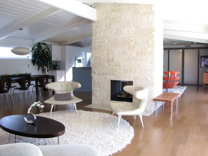 Einrichtungsideen-Wohnzimmer-midcentury-stuhl-design-weiße-wände-naturstein-verkleidung