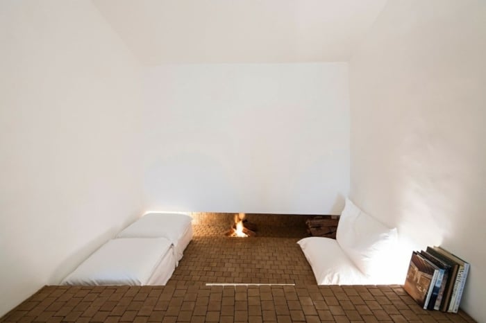 Zimmer-mit-Fliesen-und-Kamin-weiße-Kissen-und-Sitzbank