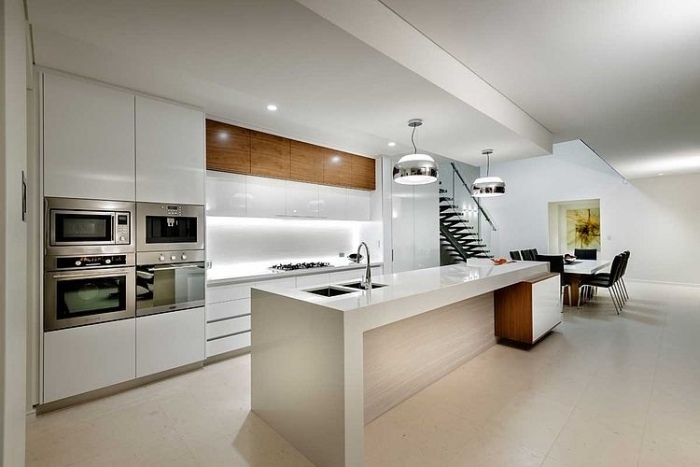 minimalistische-hochglänzend-weiße-küche-holz-elemente-stauraum-integriert-essplatz