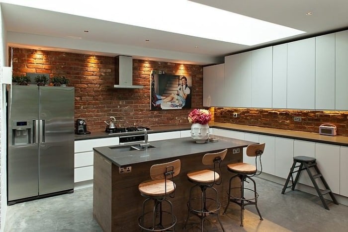 moderne-küche-design-lösung-weiße-grifflose-oberschränke-backsteinwand-beleuchtet