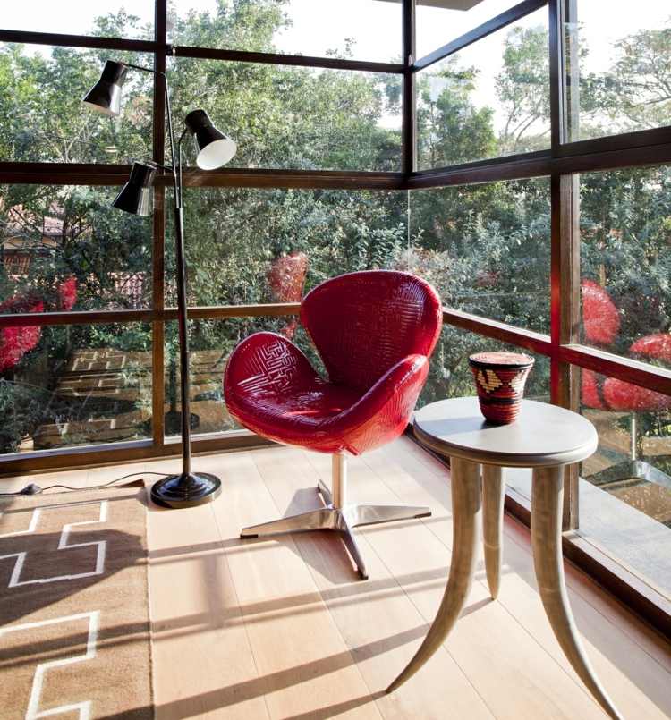 Architektenhaus Holz gemütliche Sitzecke roter Lederstuhl