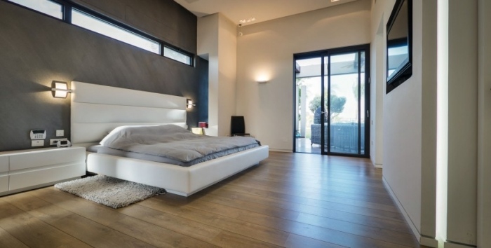 Luxus-Ferienhaus-Schlafzimmer-Polsterbett-Hohe-Decke-Schiebetür