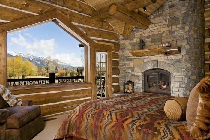 romantische-schlafzimmer-landhausstil-naturstein-wandverkleidung-rundbalken-massivholz